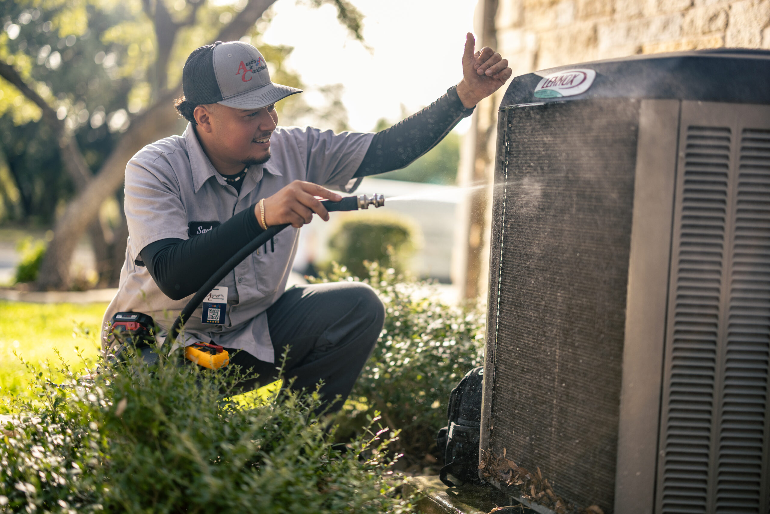 Technician cleaning outdoor Lennox HVAC unit